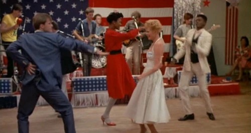 People dance in front of a live band.