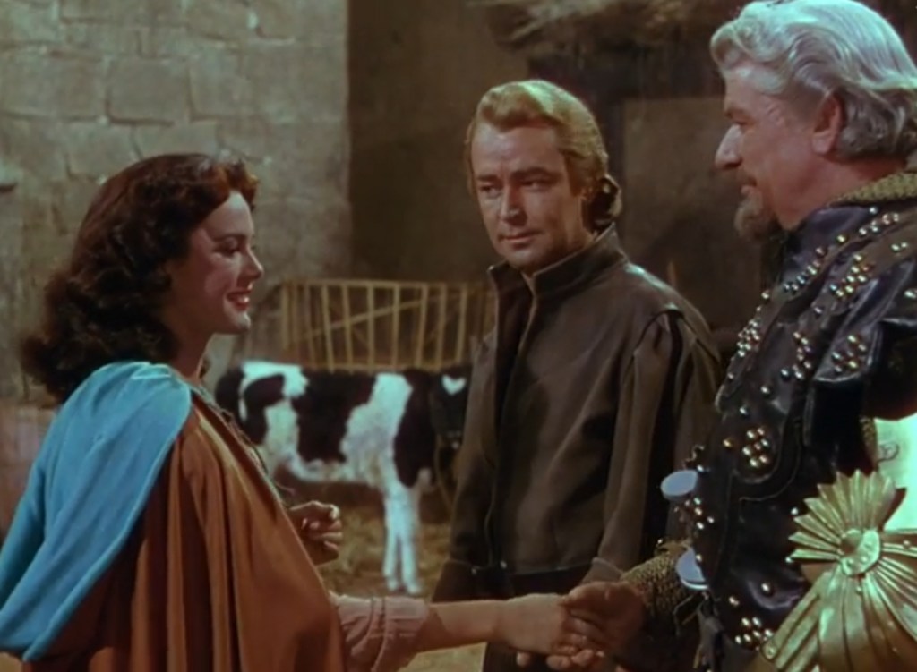 In Merry Old England, a woman shakes a man's hand while another looks on. There's a cow behind them.