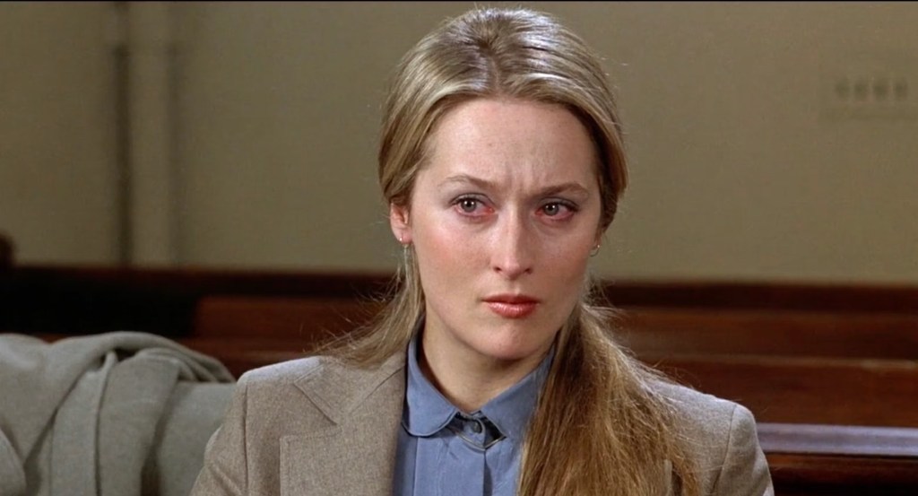 Meryl Streep, looking pale and tragic, in the courtroom, with the suit coat.