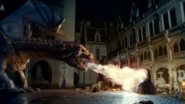 A dragon breathes fire on...a city or town or wall or pile of things. It's honestly hard to see, and the dragon is pretty fuzzy himself.