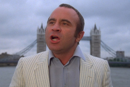 Bob Hoskins, mouth open to speak, London Bridge in the background I guess, wearing a white pinstripe suit Sam Reich would envy.