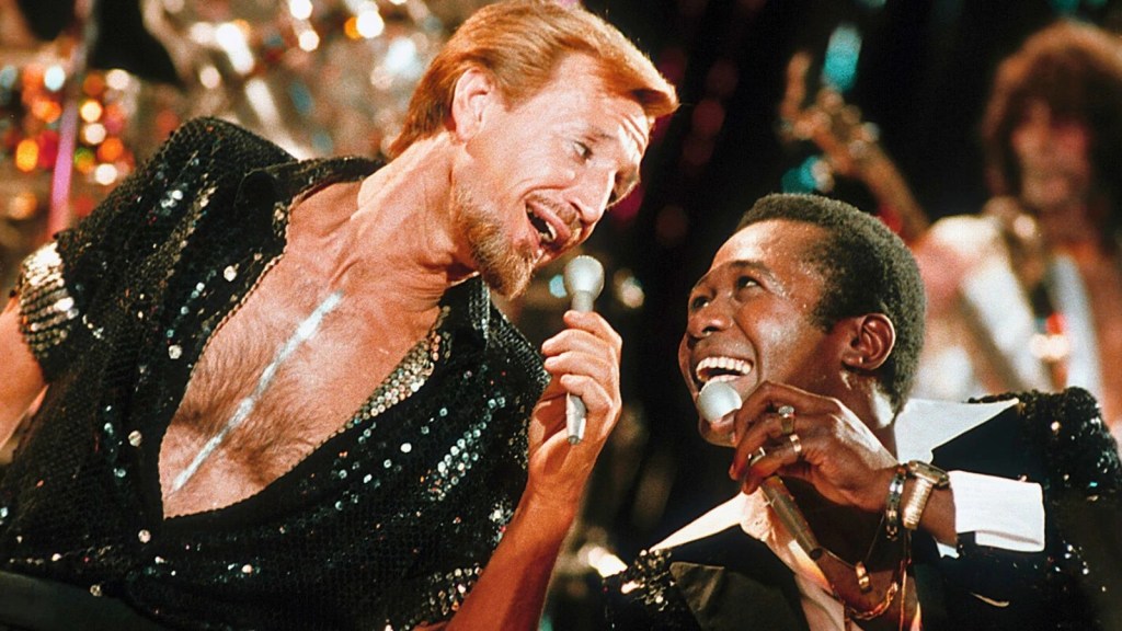 Roy Scheider and Ben Vereen are shiny and sequined and singing into silver microphones