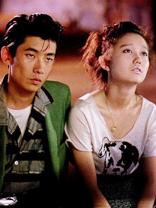 A couple–young, Asian, him in kind of a greaser style, her more 80s–stare listlessly up in the same direction