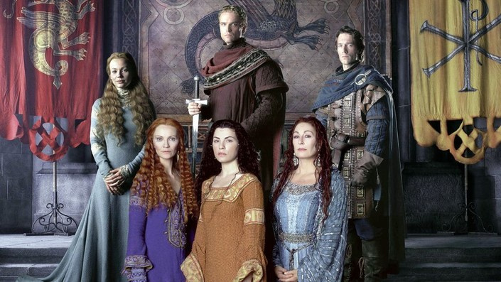The original Game of Thrones but make it Enya. Six people stand in front of ACTUAL TAPESTRIES–take that, Twilight Zone–and again look like their hair is crimped. Was the style at the time an onion on the belt and braiding your hair wet and then styling it by taking the braids out? At least that's what this looks like instead of, again, the Twilight Zone, which looks like an actual crimper.